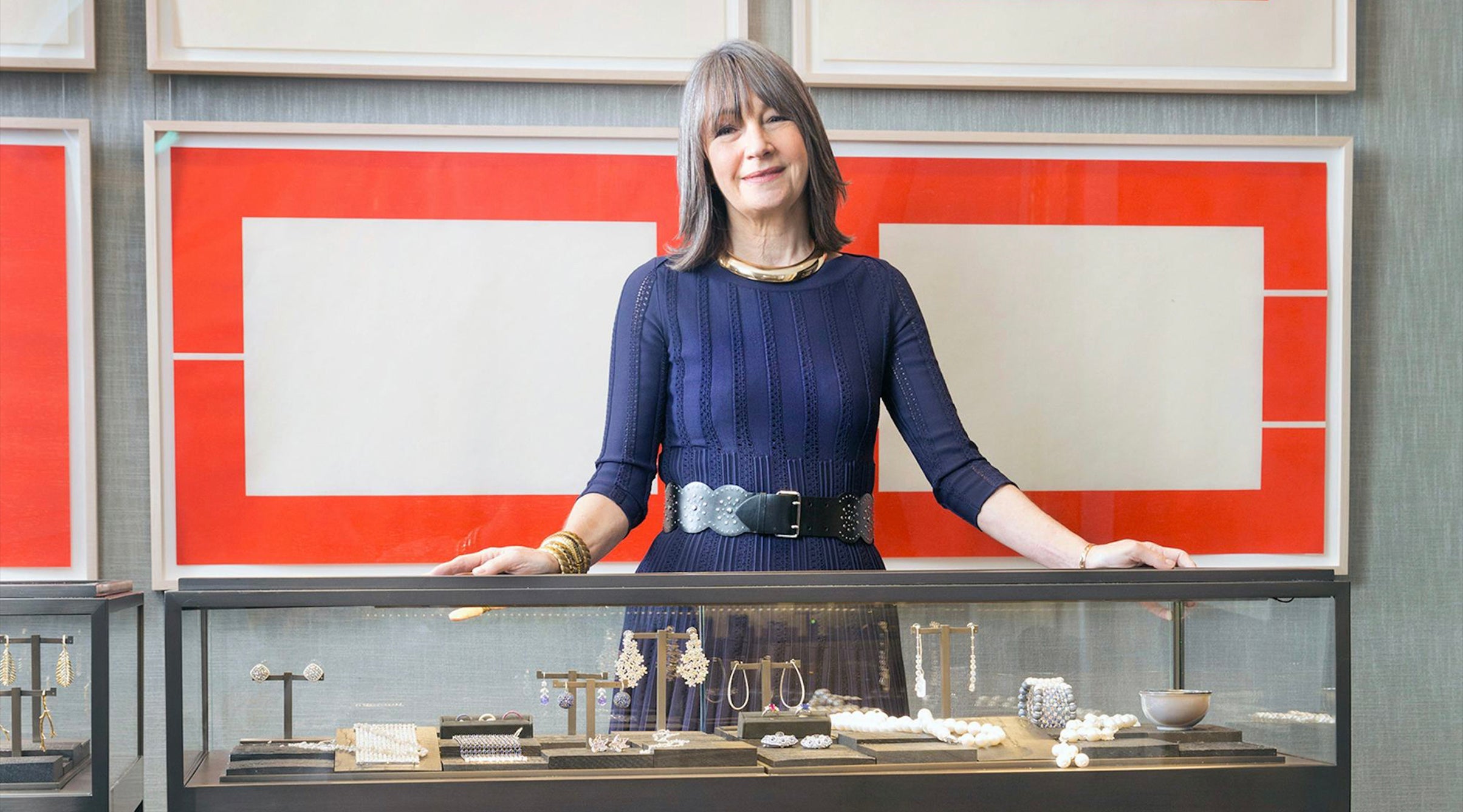 A picture of Brooke behind the jewelry counter at the New York boutique. Brooke is wearing a stack of gold bracelets on her right wrist including wave link bracelets and a domed cuff.