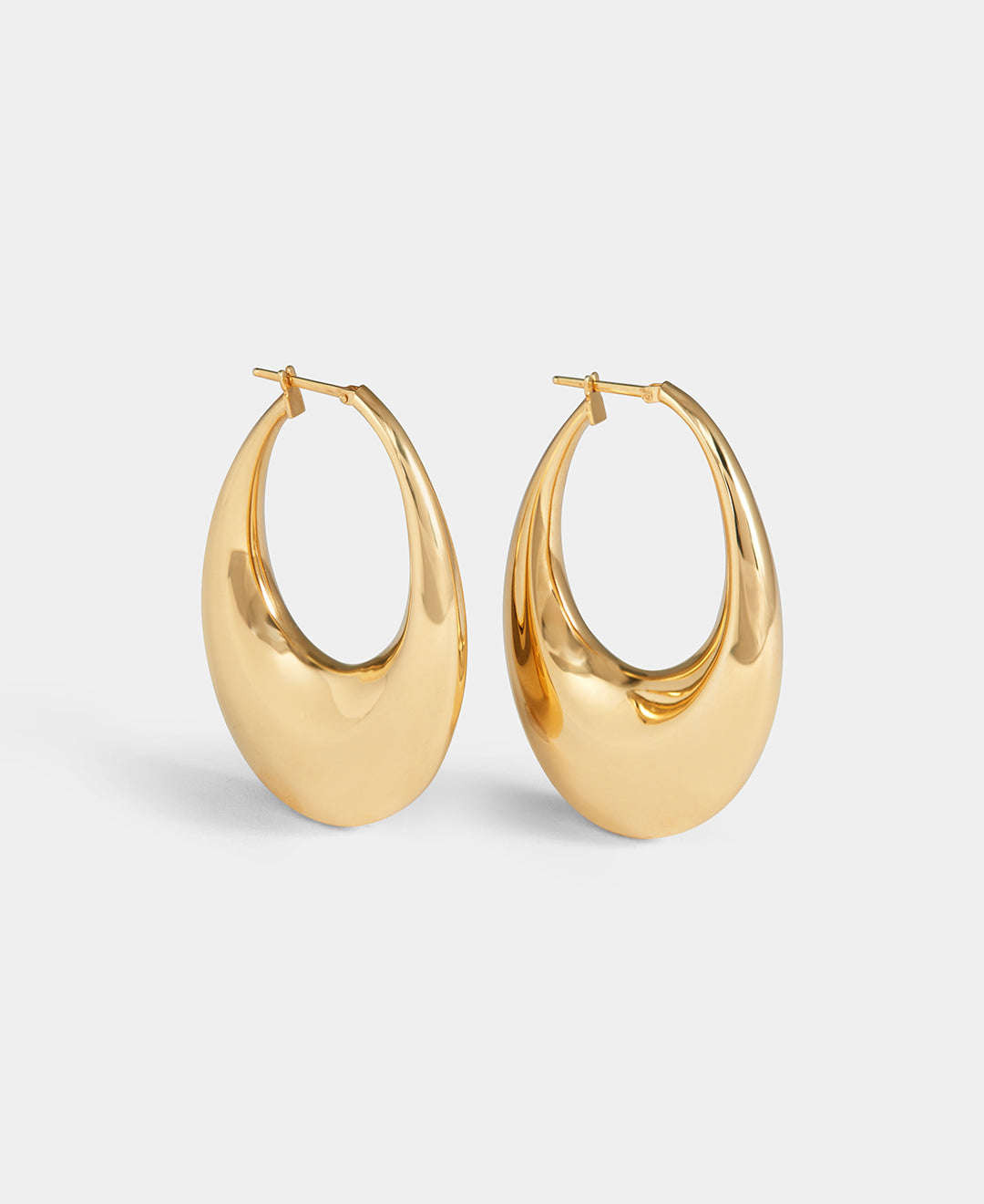 A pair of Carine earrings in yellow gold are displayed on a white background.